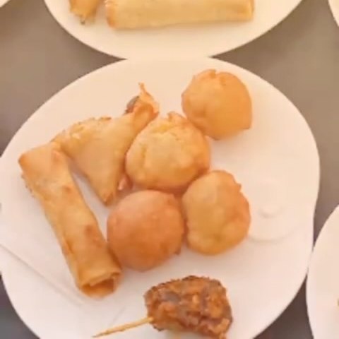 A plate of small chops: puff puff, samosa, spring rolls and suya